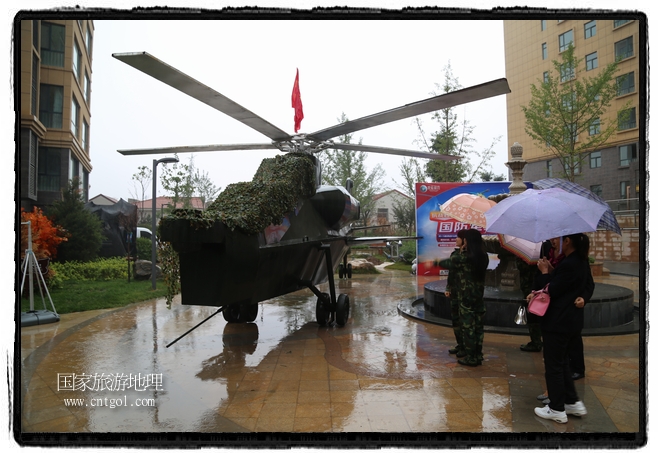 小區(qū)突然出現(xiàn)“飛機(jī)坦克”，其中殲15艦載戰(zhàn)斗機(jī)一架、99式主戰(zhàn)坦克一輛、武直-10武裝直升機(jī)一架，吸引了眾多市民雨中圍觀、合影。